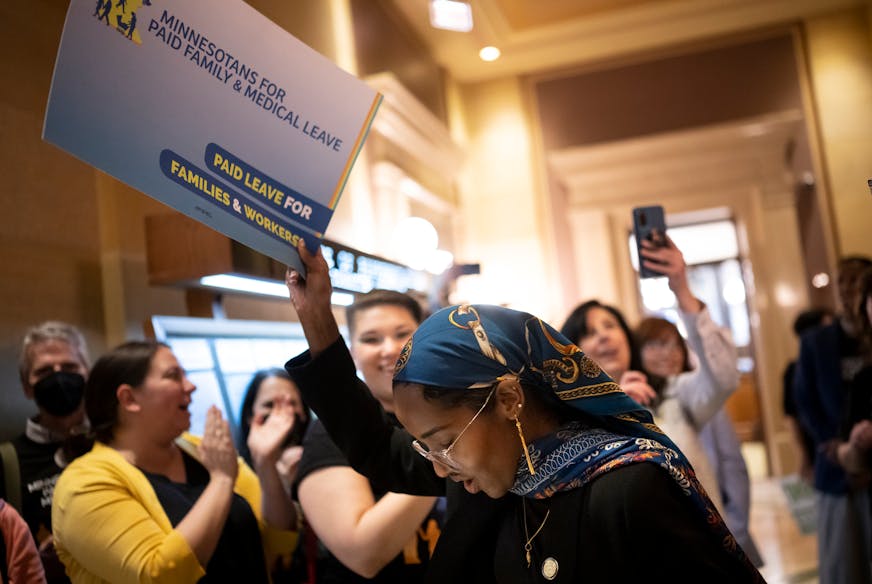 Sen. Zaynab Mohamed, DFL-Minneapolis, is cheered by paid family leave supporters as she makes her way toward the Senate Chambers Monday at the Minnesota State Capitol.