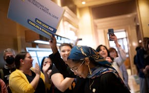 Sen. Zaynab Mohamed, DFL-Minneapolis, is cheered by paid family leave supporters as she makes her way toward the Senate Chambers Monday at the Minneso
