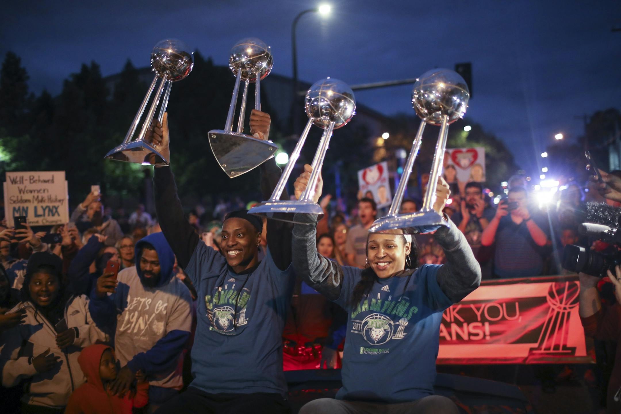 Lynx stars Sylvia Fowles, left, and Maya Moore held up all four WNBA championship trophies as they arrived at Williams Arena for the celebration of the team's latest title Thursday night.