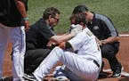 Pittsburgh Pirates pitcher Ryan Vogelsong, center, is helped by team trainers after being hit in the head by a pitch from starting pitcher Jordan Lyle
