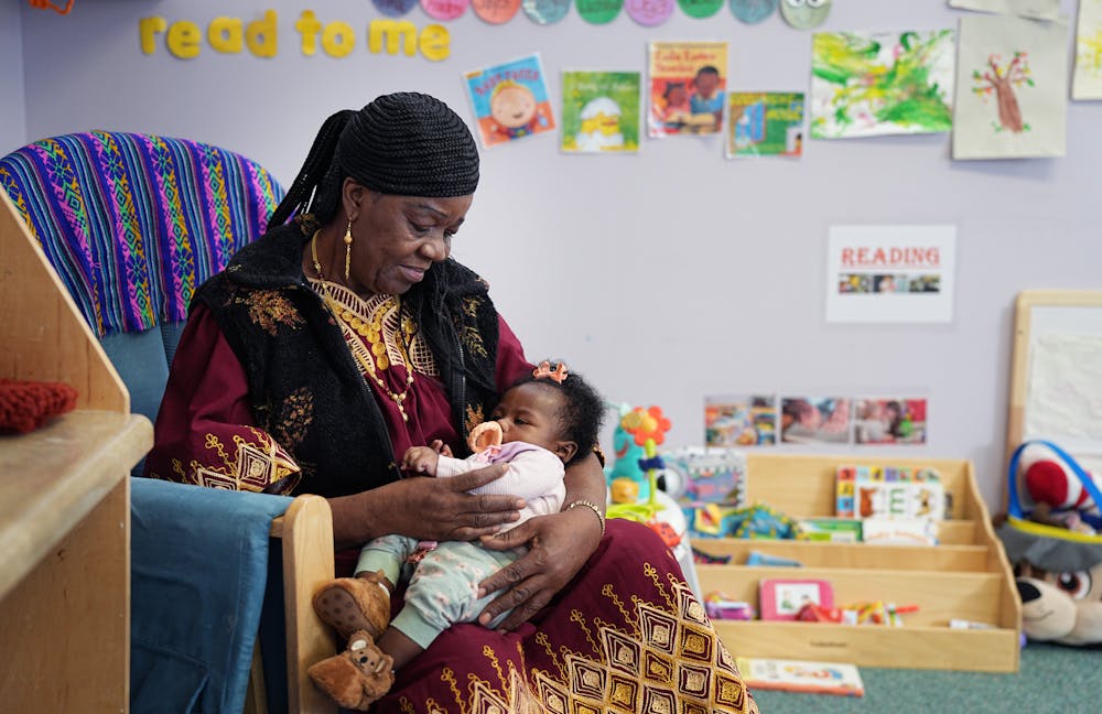 68-year-old Irene Ford sits in a chair and holds a baby as part of her foster grandparent volunteer work at the Northside Child Development Center.