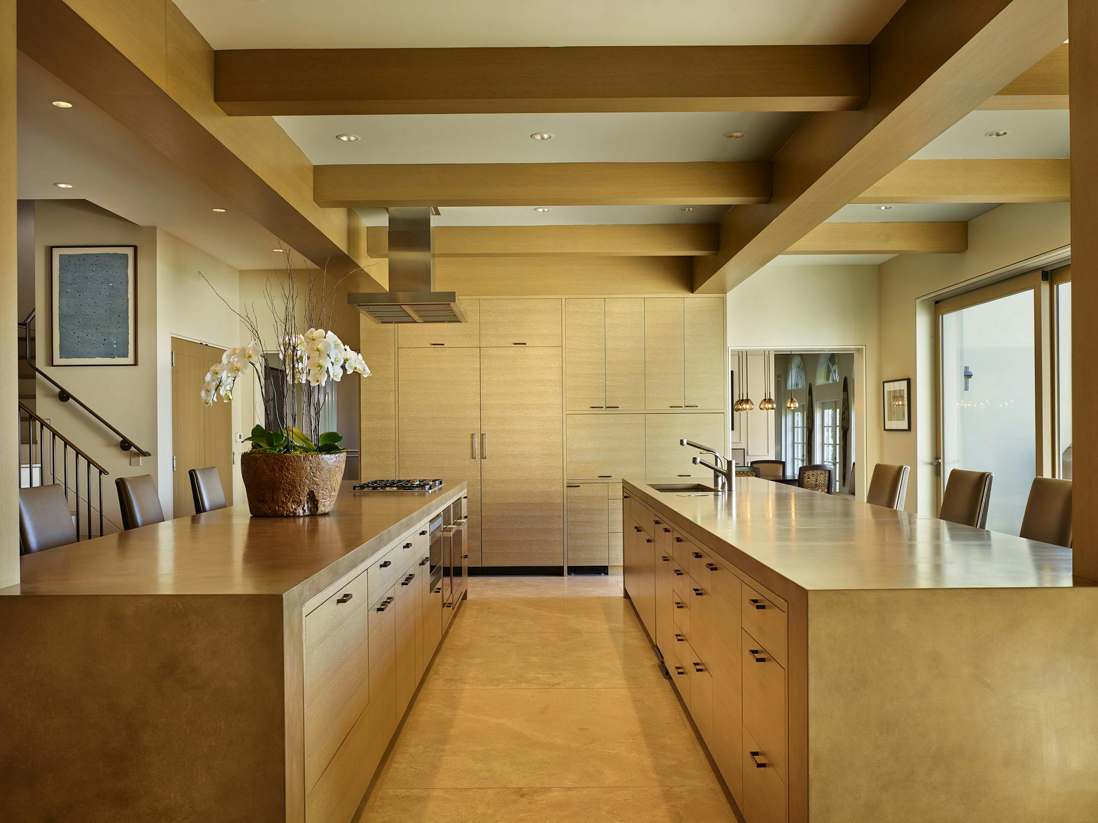 The Kirleys didn't want obstructive upper cabinets in their newly light and wide-open kitchen, so when Silk asked, "Where are you going to put the food?" two 20-foot-long islands emerged (also ideal for a kids pizza bar and/or a grown-up margarita bar). Other touches: polished concrete countertops, cerused white-oak cabinets and beams, large-format honey-colored limestone flooring and a retractable kitchen hood. (Benjamin Benschneider/The Seattle Times/TNS) ORG XMIT: 1185012