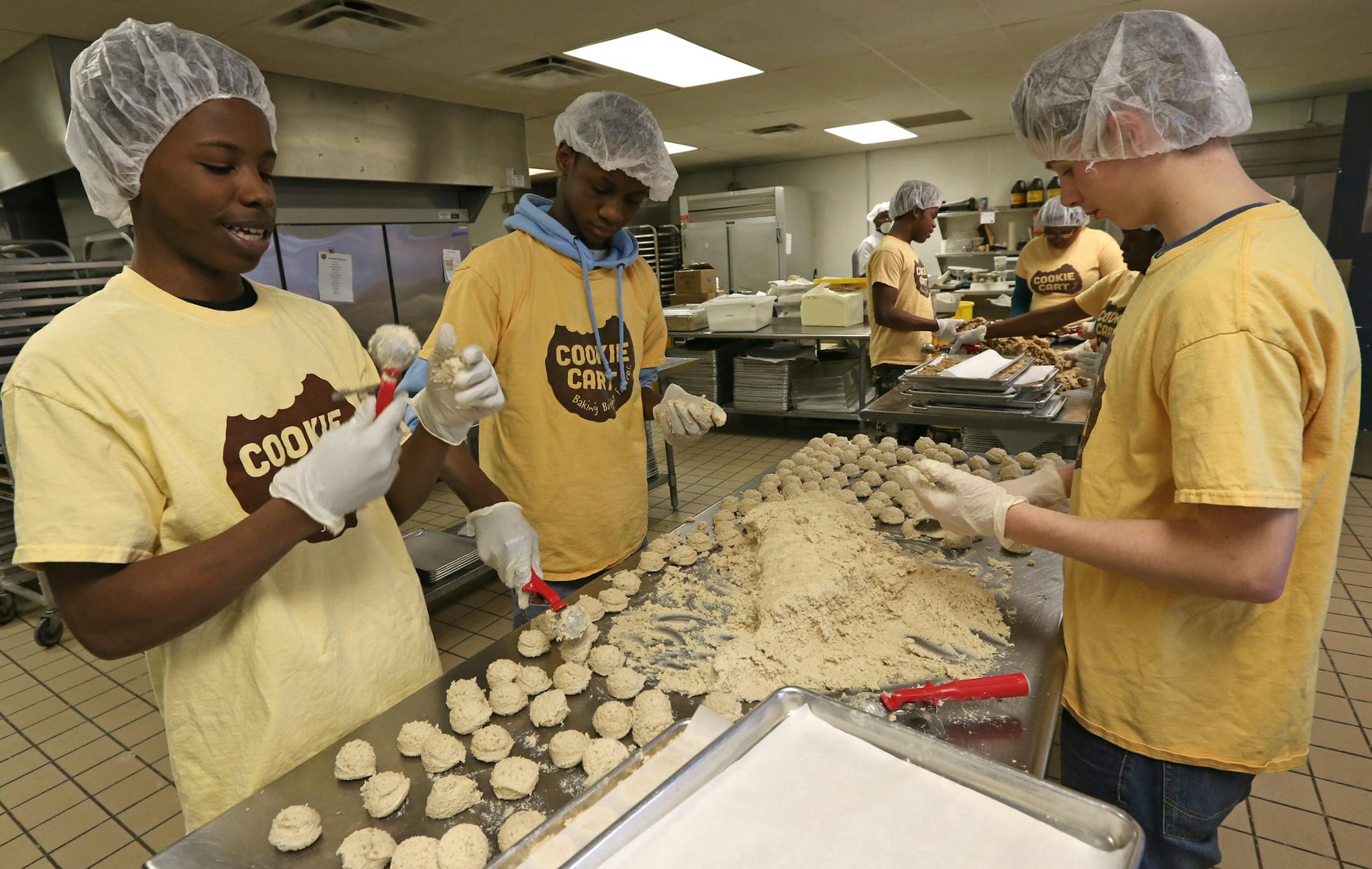 (left to right) Steven Chambers, Omar Pope and Nikos Loman made coconut cookies on 2/6/14, at the Cookie Cart. The Cookie Cart is a fixture of north Minneapolis, a program that teaches high-school kids bakery and life skills.] Bruce Bisping/Star Tribune bbisping@startribune.com Steven Chambers, Omar Pope, Nikos Loman/source.