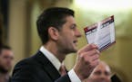 House Speaker Paul Ryan (R-Wis.), accompanied by other Republican legislators, holds up an example of what a "postcard" tax return might look like dur