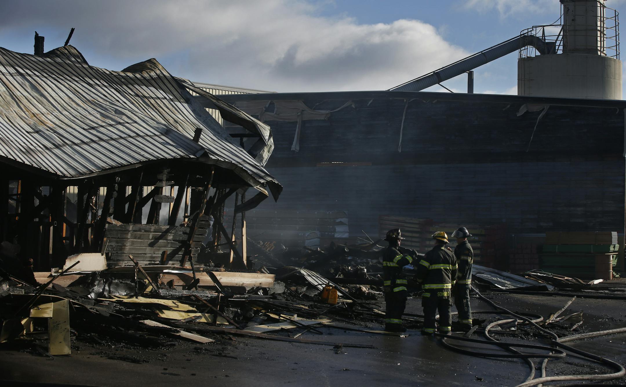Firefighters survey the remains of a 3 alarm fire Sunday morning at Shaw Stewart Lumber, 645 NE. Johnson St., Minneapolis, Minnesota. just east of Interstate 35W. ]Richard Tsong-Taatarii/rtsong-At taatarii@startribune.com