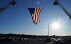 A giant American flag hung between two ladder trucks ahead of a memorial service for Burnsville police officers Paul Elmstrand, 27, Matthew Ruge, 27, 