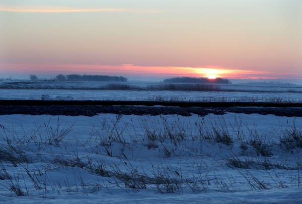 The sun rises behind a set of railroad tracks near the now closed and abandoned former U.S. border crossing Thursday, Jan. 26, 2017, in Noyes, MN. The