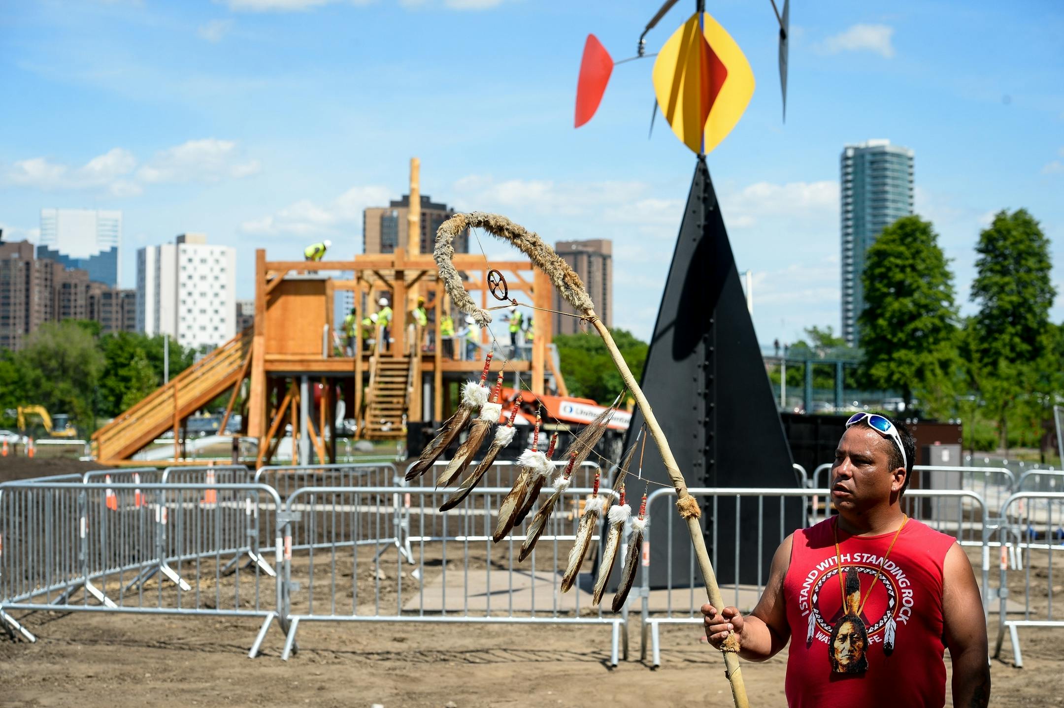 Tommy Tiokasin, with the Standing Rock Sioux Nation, held a staff from his tribal community as the first part of the "Scaffold" sculpture was dismantled behind him on Friday, June 2. Tiokasin says he is related to two of the men hung in the Dakota 38 hangings.