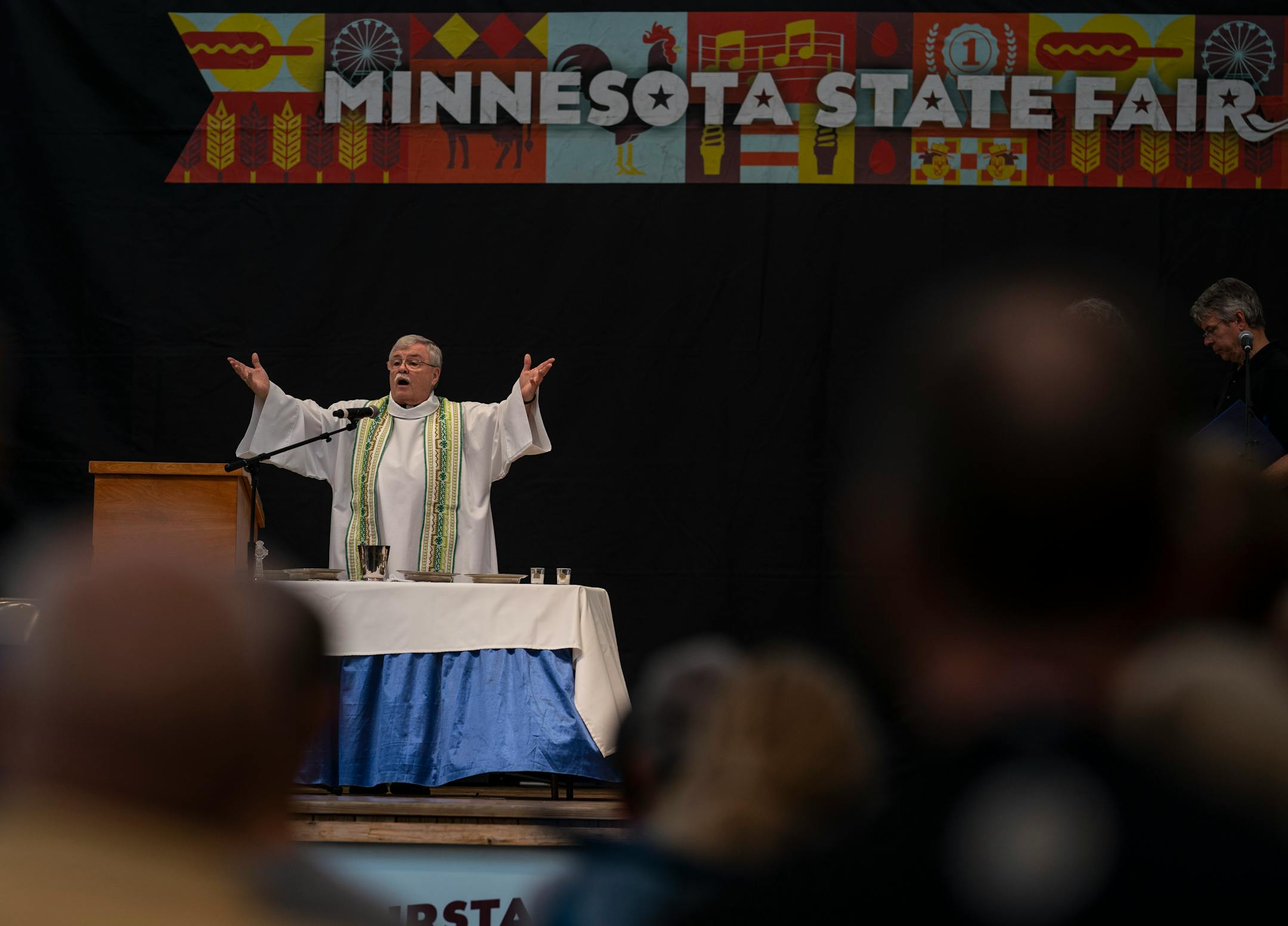 The Rev. Robert Fitzpatrick (retired) spoke during Mass celebrated in Baldwin Park on the Minnesota State Fairgrounds. The Mass was hosted by Corpus Christi Catholic Church in Roseville.