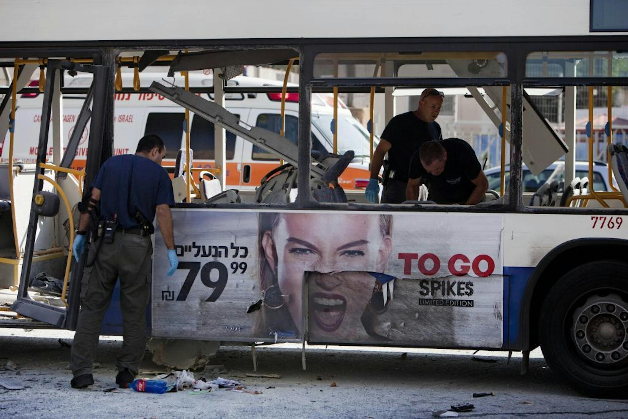Israeli police officers examine a blown up bus at the site of a bombing in Tel Aviv, Israel, Wednesday, Nov. 21, 2012. A bomb ripped through an Israeli bus near the nation's military headquarters in Tel Aviv on Wednesday, wounding at several people, Israeli officials said. The blast came amid a weeklong Israeli offensive against Palestinian militants in Gaza.