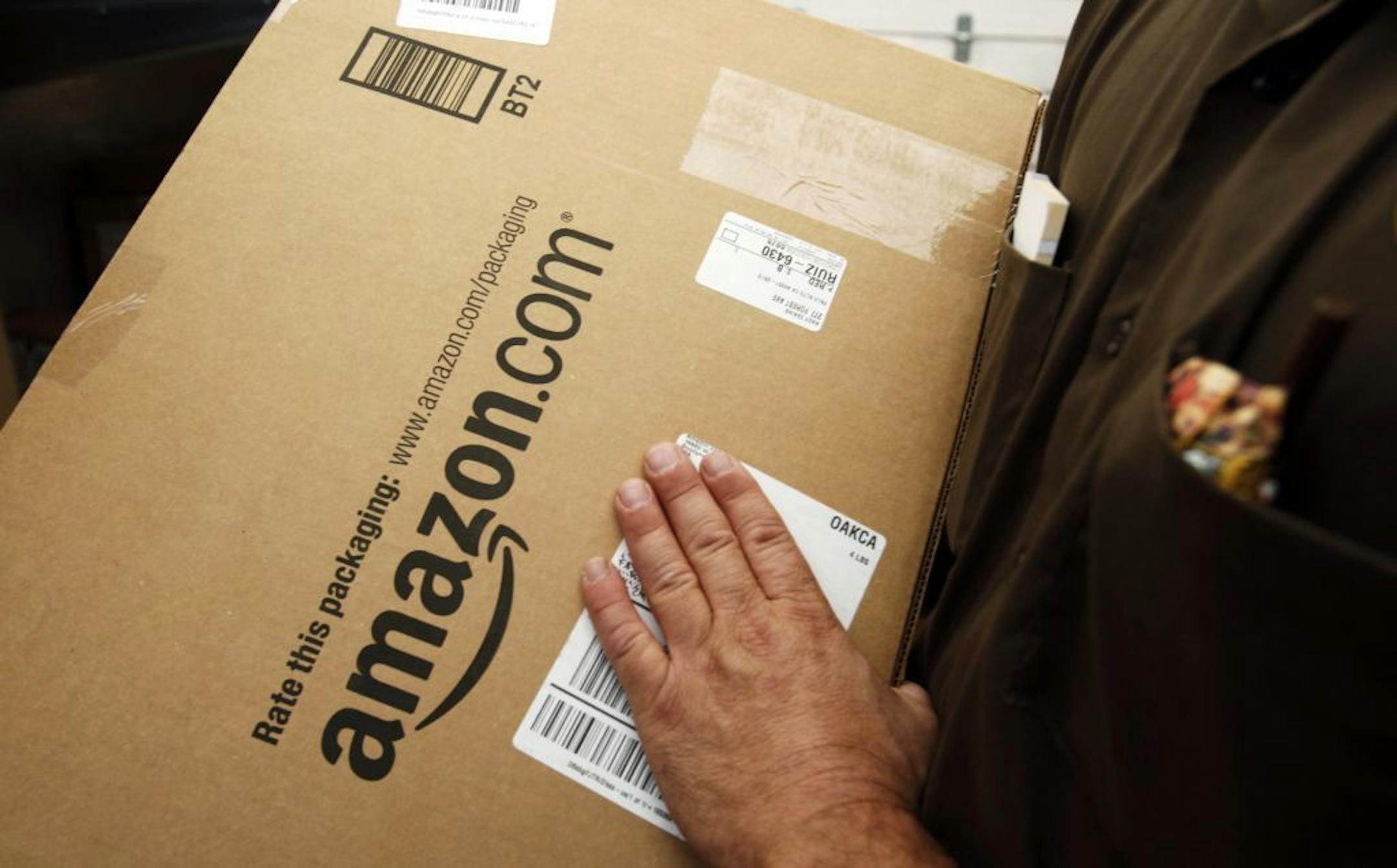 FILE - In this Oct. 18, 2010 file photo, an Amazon.com package is prepared for shipment by a United Parcel Service driver in Palo Alto, Calif. Michigan state legislators in May 2013 are pushing measures to capture the state's share of hundreds of millions of dollars in annual taxes from Amazon, eBay and other Internet retailers. Under bipartisan bills being debated in the state House, Internet retailers would have to charge sales tax if they have distribution centers or warehouses in Michigan or