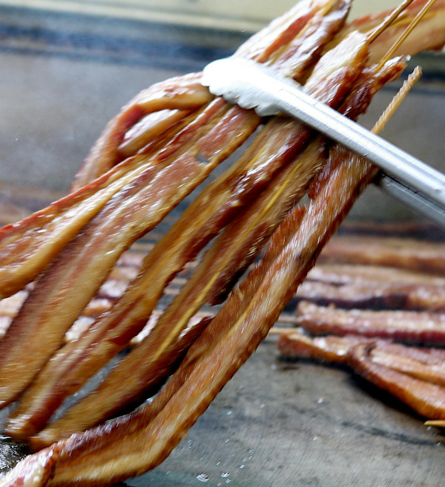 Bacon on a stick is cooked all day long in the Big Fat Bacon stand at the Minnesota State Fair August 25, 2013.(Courtney Perry/Special to the Star Tribune)