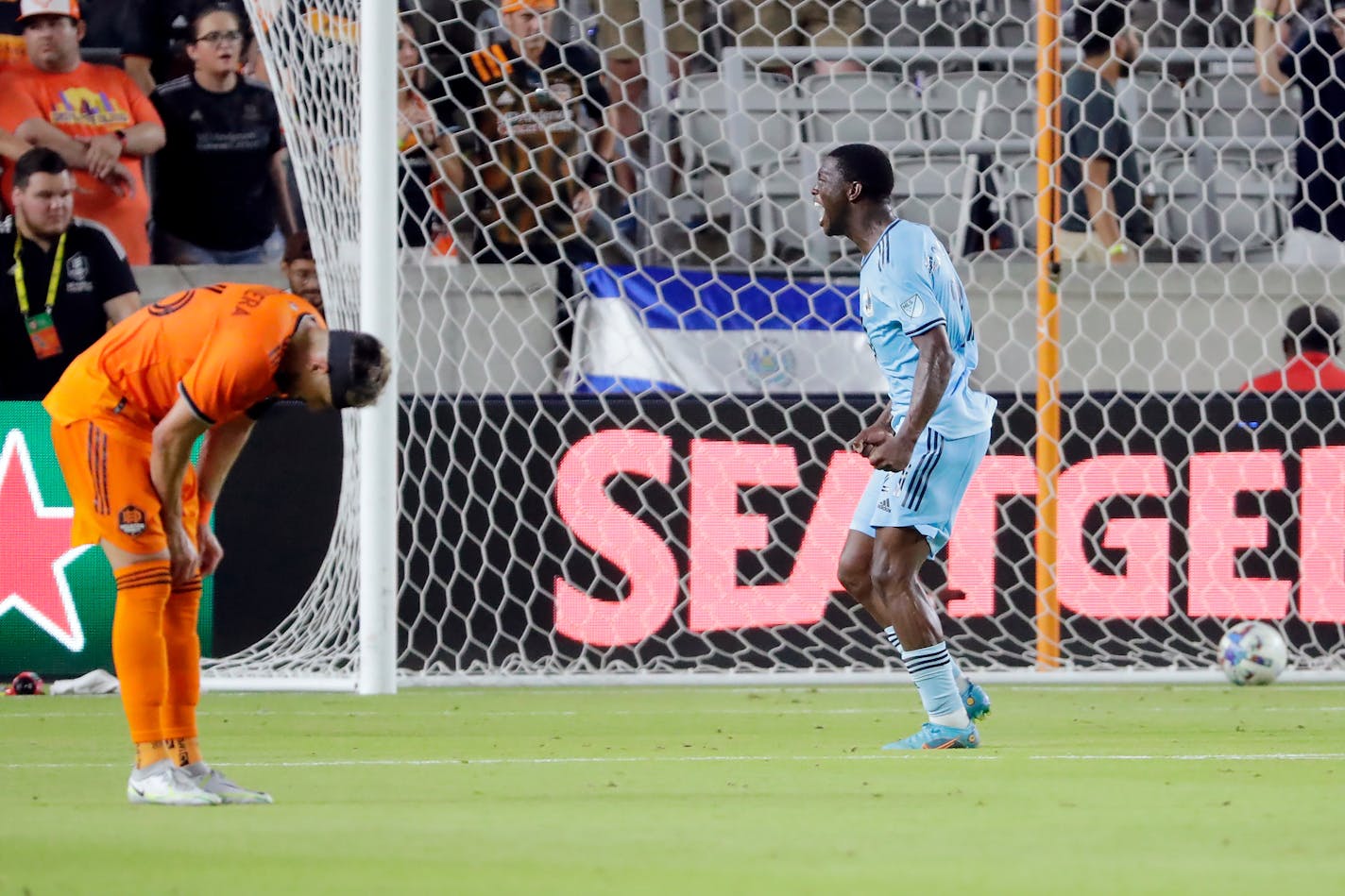 Minnesota United forward Bongokuhle Hlongwane, right, reacts to his goal as he runs past Houston Dynamo midfielder Hector Herrera, left, during the second half of an MLS soccer match Saturday, July 23, 2022, in Houston. (AP Photo/Michael Wyke)