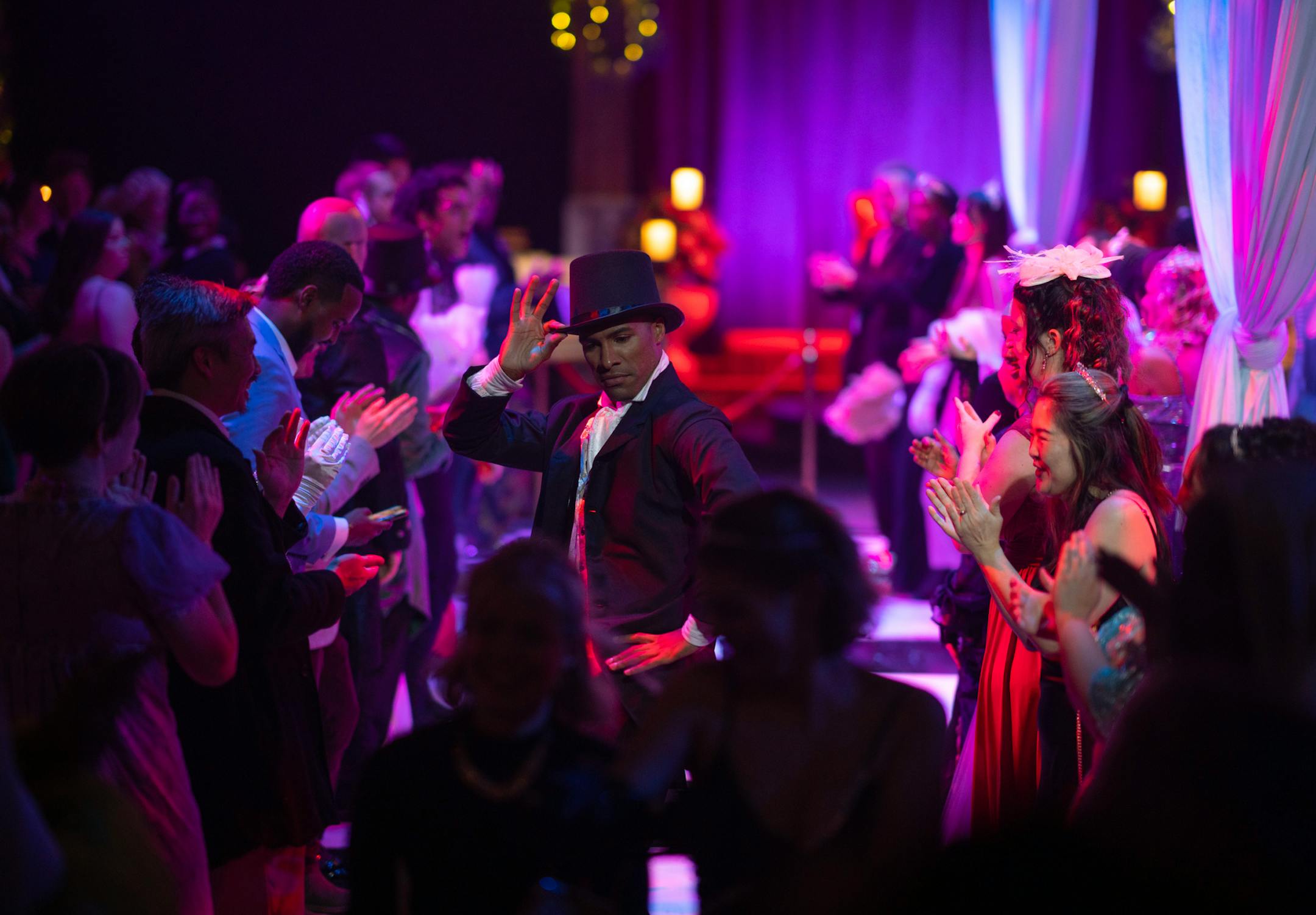 A company member danced along a gauntlet of guests on opening night of The Queen's Ball: A Bridgerton Experience.