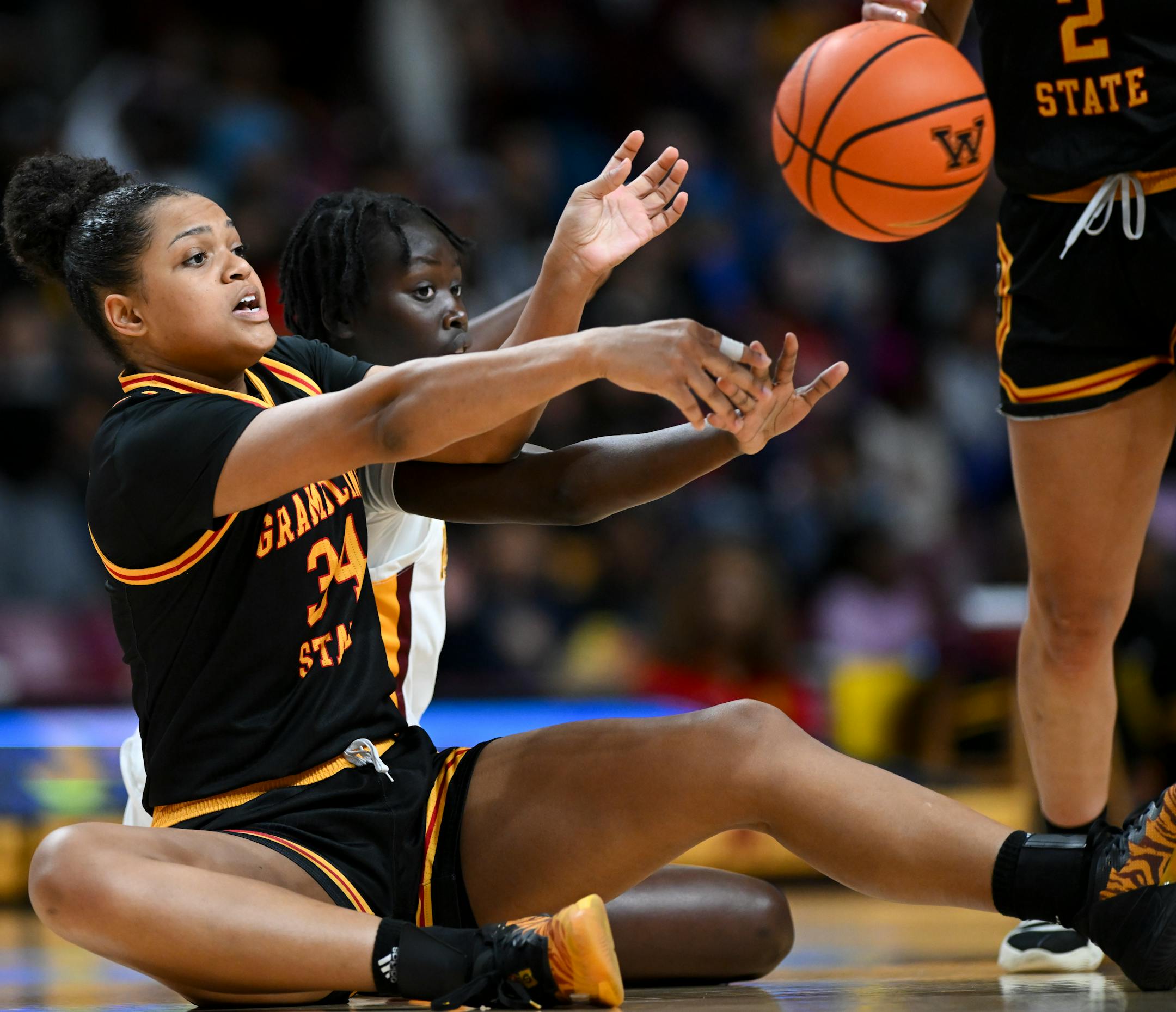 Minnesota Gophers forward McKynnlie Dalan (34) passs the ball away after scrambling to the floor against Minnesota Gophers guard Ajok Madol (12) in the second half.