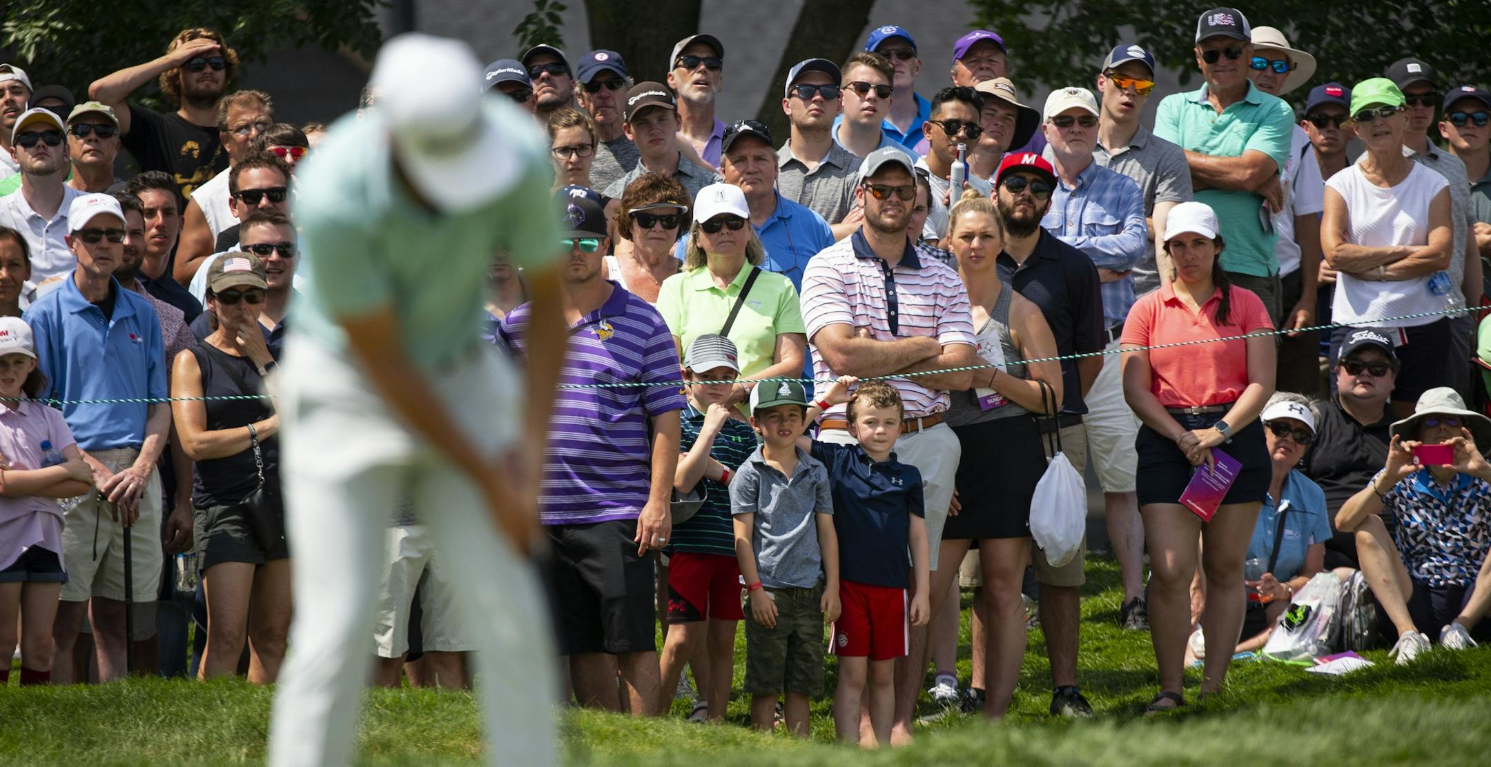 A large crowd watches Matthew Wolff putt.