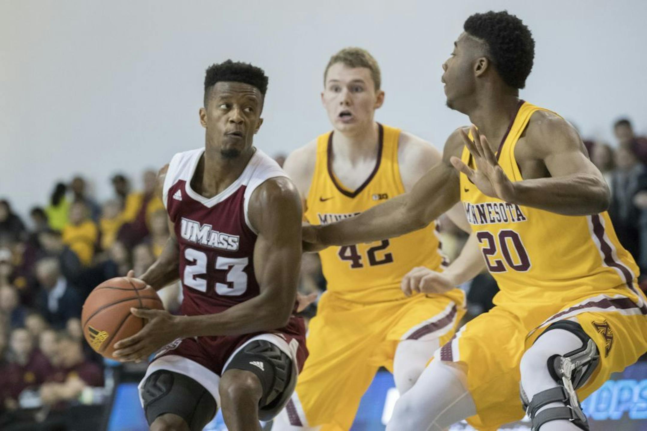Minnesota forward Davonte Fitzgerald (20) and forward Michael Hurt (42) guard UMass guard C.J. Anderson (23) during the second half of an NCAA college basketball game, Friday, Nov. 24, 2017, in New York. Minnesota won 69-51.
