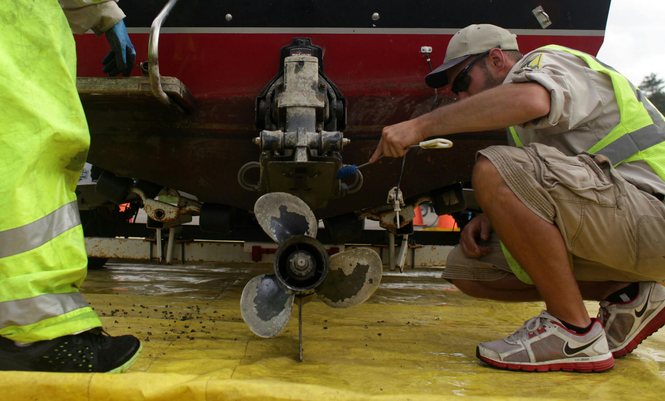Joe Hale and Ben Troop, DNR Watercraft Inspectors, scrub dead zebra mussels off a boat that had been fined $300 for not following aquatic invasive species laws, at Gray's Bay boat ramp on Thursday afternoon.] The Minnesota Department of Natural Resources is ramping up enforcement of aquatic invasive species. MONICA HERNDON monica.herndon@startribune.com Minnetonka, MN 07/10/14 ORG XMIT: MIN1407101738460906