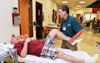 John Meeker, 51, of Nottingham, Pa., has his knee worked on by physical therapist Mike Degregorio at Allegheny Health Network Outpatient Care Center i
