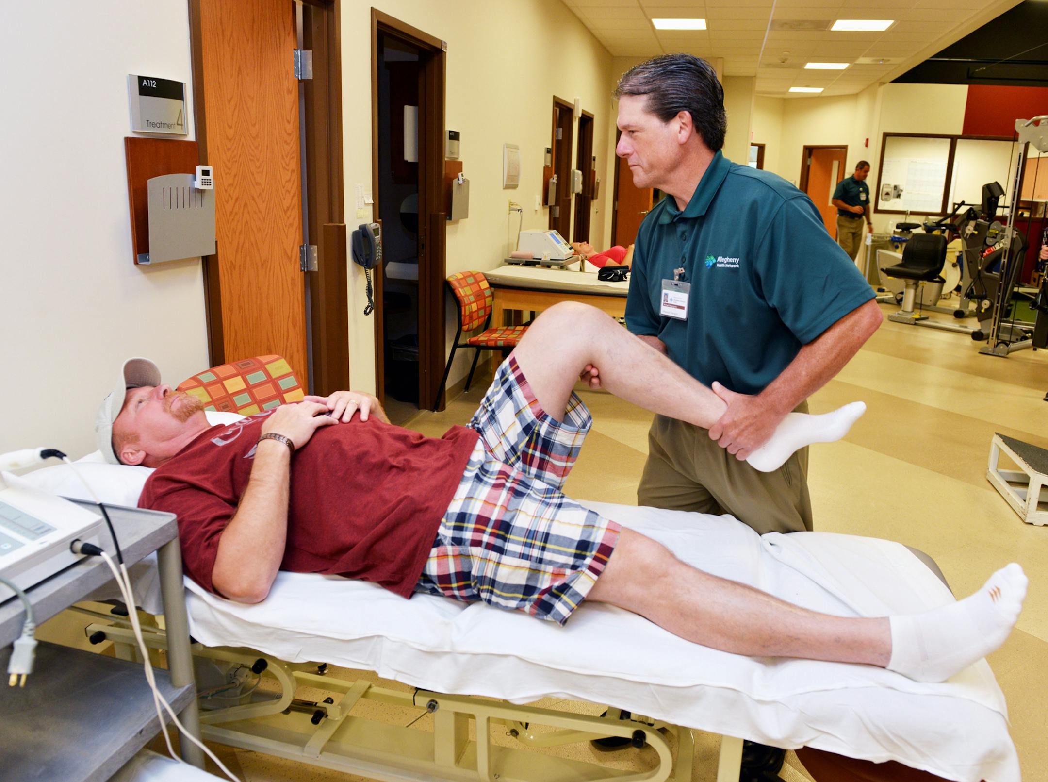 John Meeker, 51, of Nottingham, Pa., has his knee worked on by physical therapist Mike Degregorio at Allegheny Health Network Outpatient Care Center in McMurray, Pa. Meeker had a total knee replacement and was discharged the same day as his surgery. (Robin Rombach/Pittsburgh Post-Gazette/TNS)