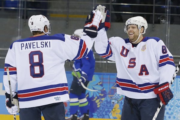 USA forward Phil Kessel, right, celebrates his second goal with teammate Joe Pavelski during the 2014 Winter Olympics men's ice hockey game against Sl