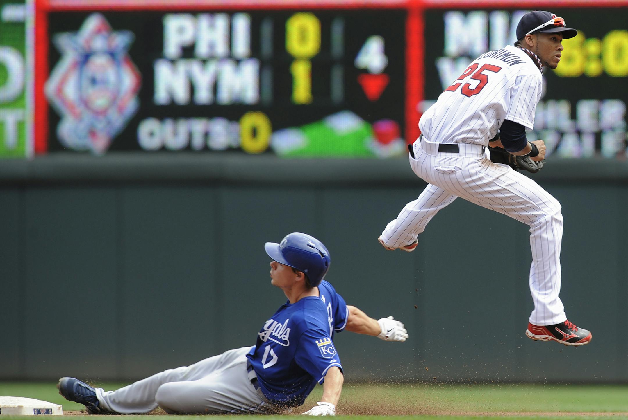 Minnesota Twins shortstop Pedro Florimon, right, jumps to avoid the slide of Kansas City Royals' Chris Getz, left, after getting the force at second on a double play during the fourth inning of a baseball game, Thursday, Aug. 29, 2013, in Minneapolis. (AP Photo/Tom Olmscheid)