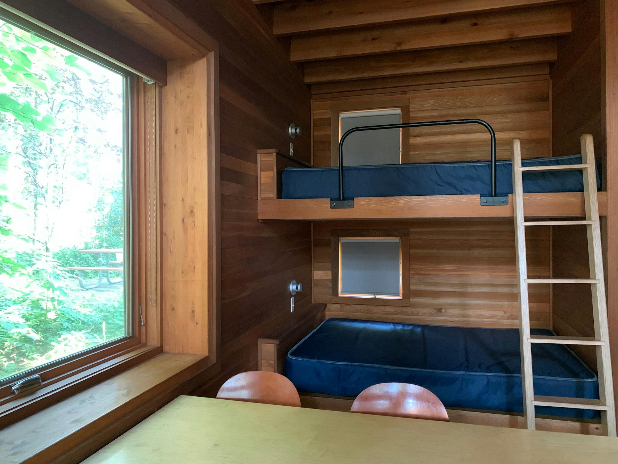 Large windows bring plenty of light into the Pine Forest camper cabins' sleeping and dining areas.