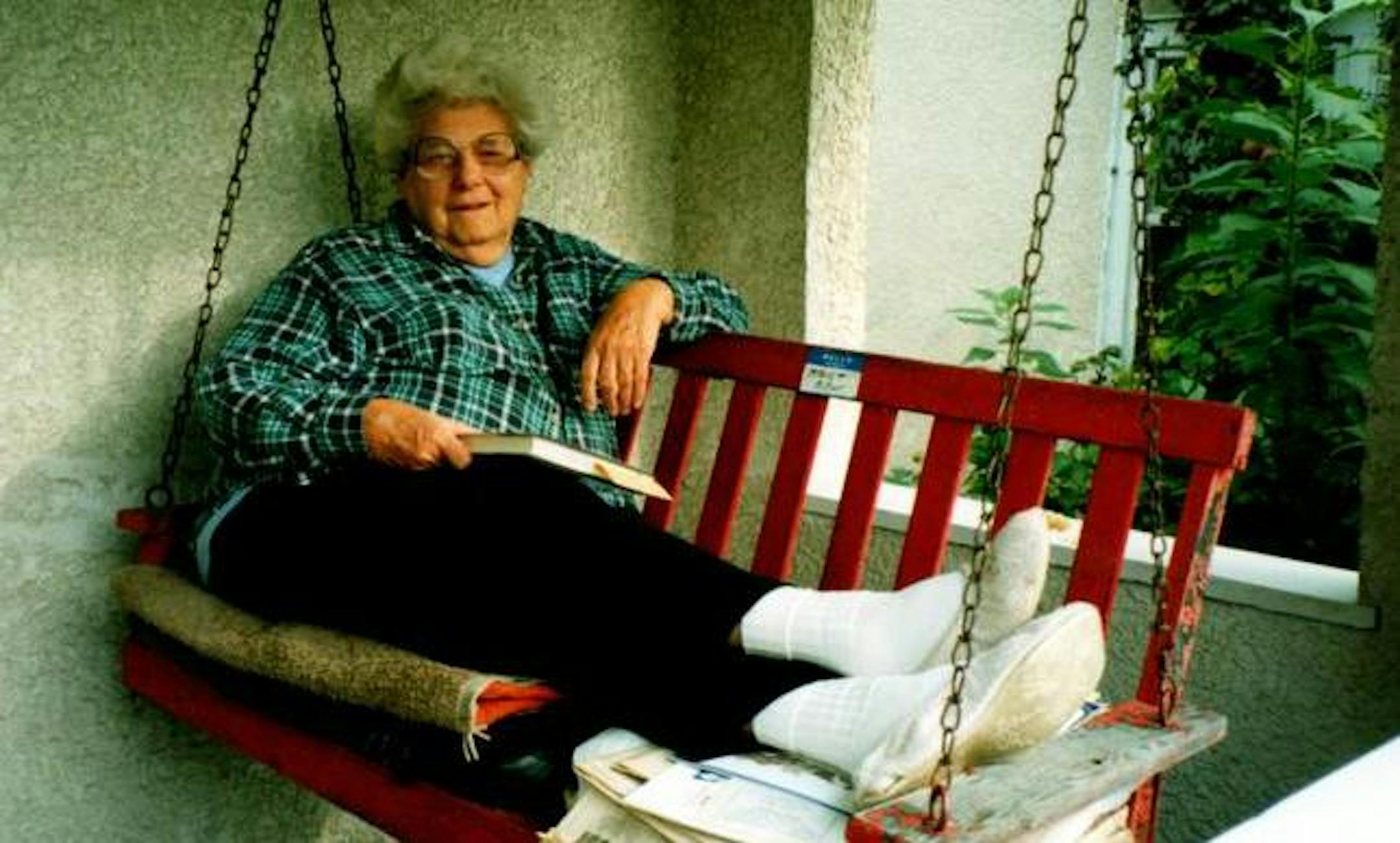 Mildred Miller relaxed with a book on her red swing on the porch of her Powderhorn neighborhood house in Minneapolis.