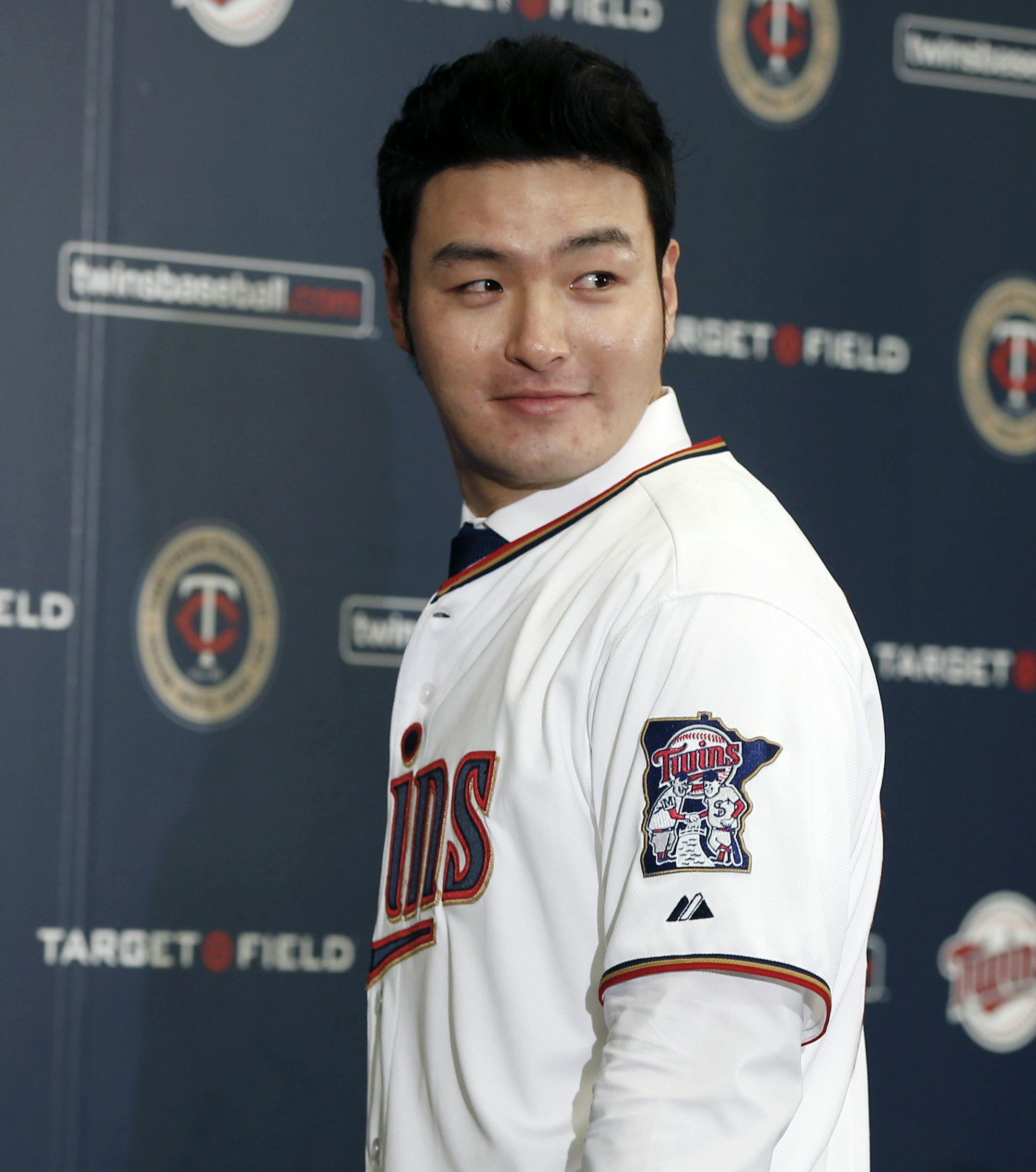 Byung Ho Park of South Korea models his new jersey as he meets the media, Wednesday, Dec. 2, 2015, in Minneapolis, after signing a three-year contract with the Minnesota Twins baseball team. (AP Photo/Jim Mone)