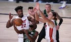 Boston Celtics guard Kemba Walker (8) attempts to maintain control of the ball in front of Miami Heat forward Jimmy Butler (22) and Kelly Olynyk