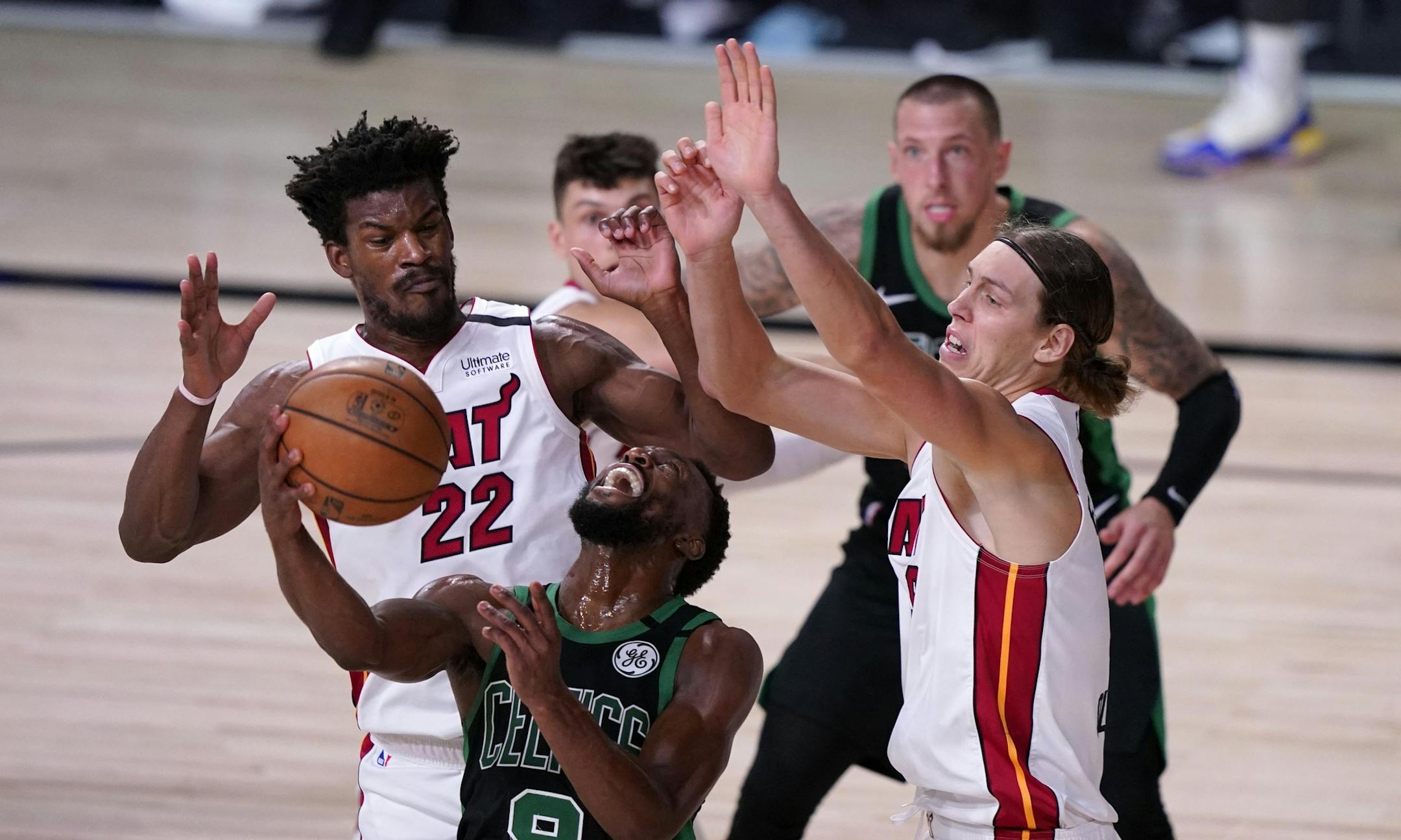 Boston Celtics guard Kemba Walker (8) attempts to maintain control of the ball in front of Miami Heat forward Jimmy Butler (22) and Kelly Olynyk