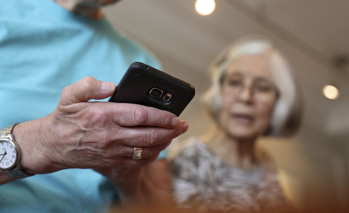 Pam Washburn looks on as her husband, Mel, uses his phone in their Lincoln Park apartment on Sept. 7, 2022.