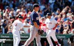 Minnesota Twins' Tommy Milone, center, walks back to the mound after giving up a three-run home run to Boston Red Sox's Travis Shaw, right, during the