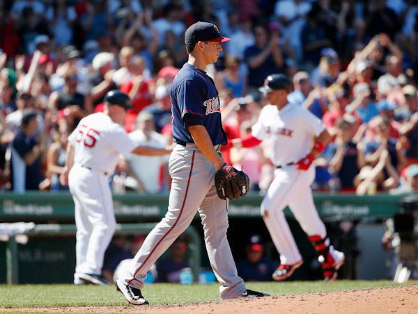 Minnesota Twins' Tommy Milone, center, walks back to the mound after giving up a three-run home run to Boston Red Sox's Travis Shaw, right, during the