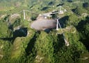 FILE- In this March 26, 2003, file photo, the world's largest radio telescope is seen from the air, at the Arecibo Observatory, in Puerto Rico. The fu