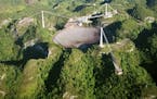 FILE- In this March 26, 2003, file photo, the world's largest radio telescope is seen from the air, at the Arecibo Observatory, in Puerto Rico. The fu