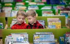 Twin brothers Camden, left, and Coffey Weston sifted through books at the Ramsey County Library in Roseville before story time in January 2020.
