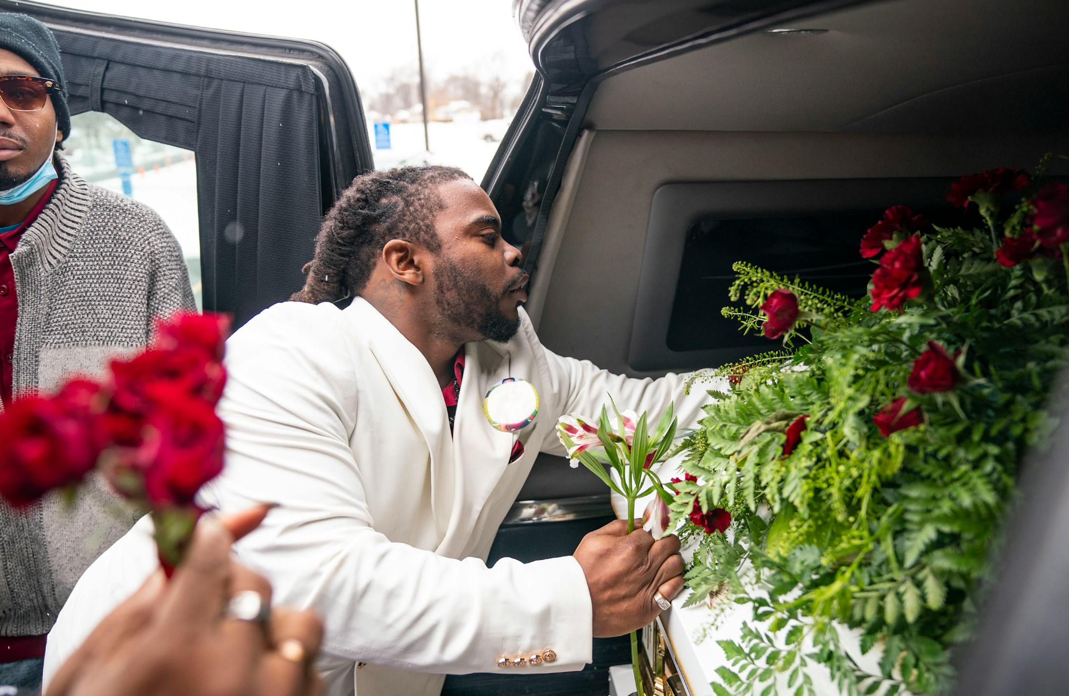Cortez Rice, Jahmari Rice's father, hands out roses and flowers from his son's casket to other family members after his funeral Wednesday.