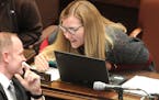 Democratic state Sen. Nicole Mitchell, right, from Woodbury, speaks with Sen. Robert D. Farnsworth, R-Hibbing, on the floor of the Senate on April 2 i