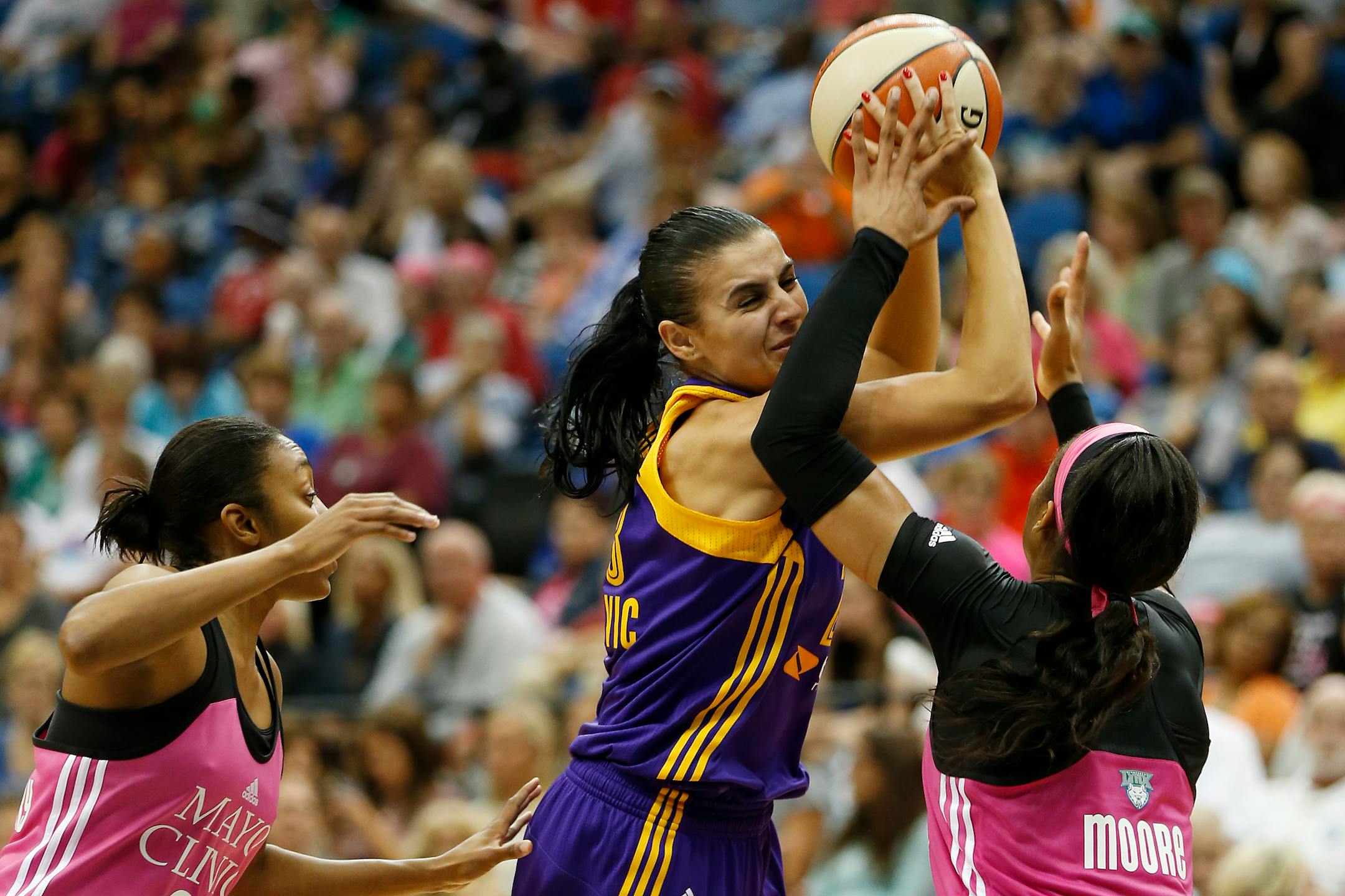 Los Angeles Sparks guard Ana Dabovic, center, defends the ball against Minnesota Lynx forward Maya Moore, right, and guard Renee Montgomery, left, during the first half of a WNBA basketball game, Sunday, Aug. 9, 2015, in Minneapolis. (AP Photo/Stacy Bengs)