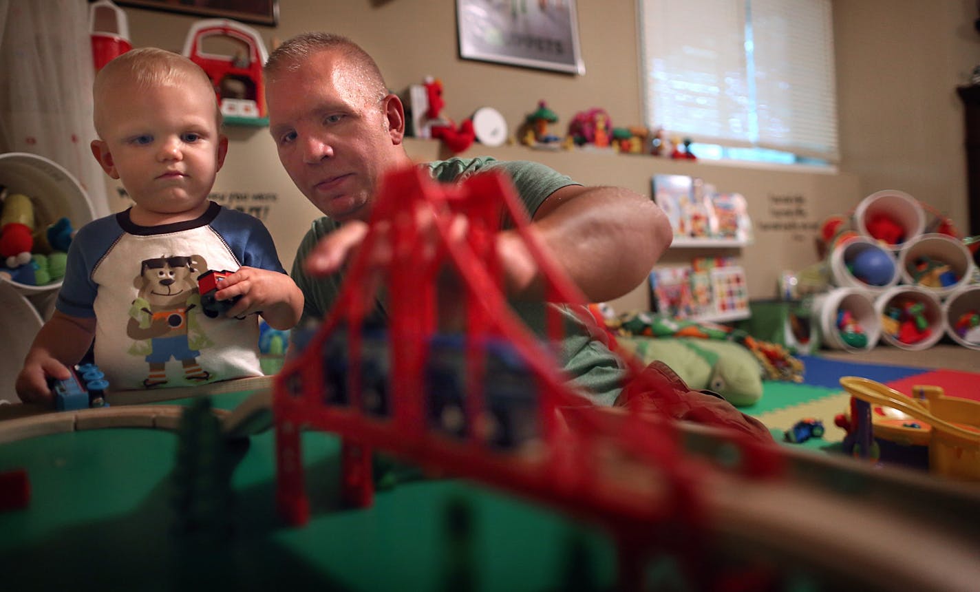 35W bridge collapse survivor Garrett Ebling played with toy cars and trucks with his 16-month-old son, Cooper, at the family's Andover home.