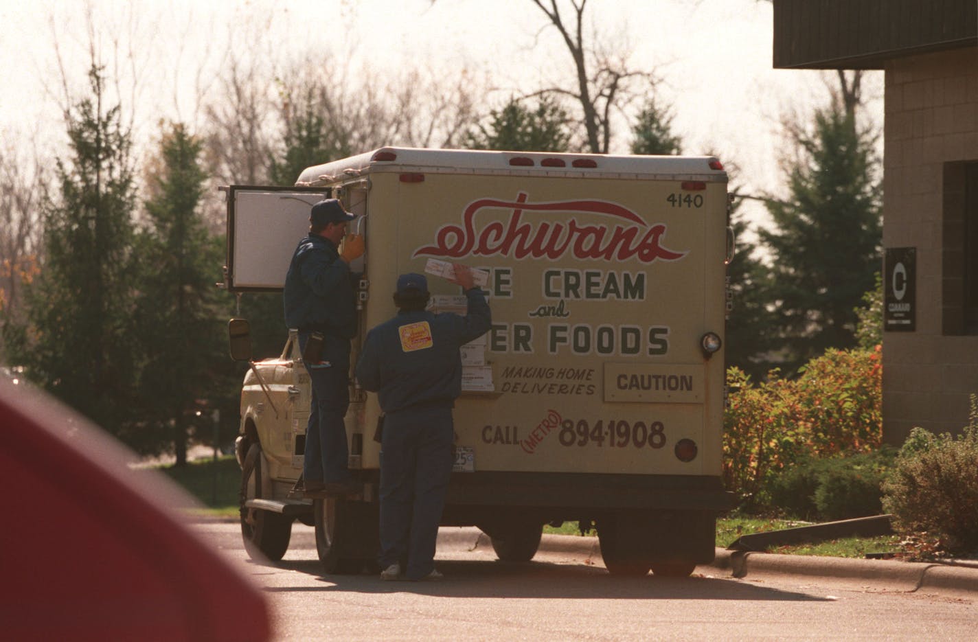 A Schwan's delivery truck and two people delivering products to a business in an Eden Prarie industrial park. // Schwan's ice cream // 1994 Star Tribune photo by Tom Sweeney.