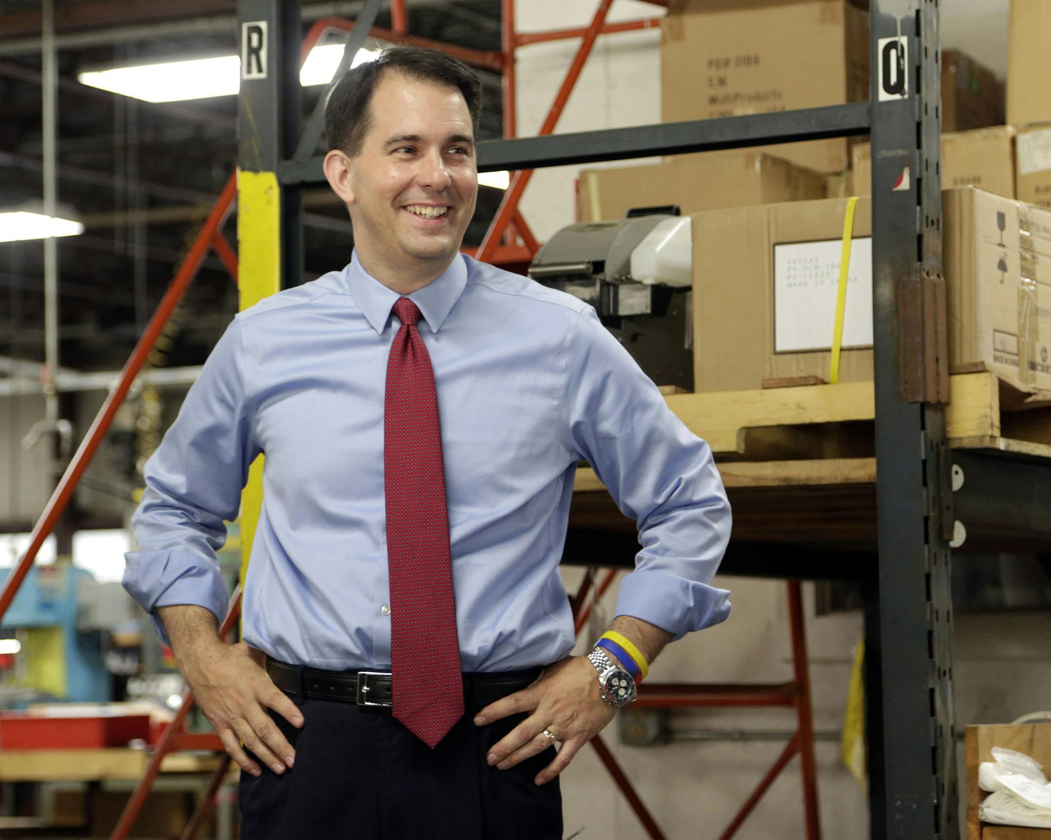 In this Sept. 23, 2014 photo Republican Wisconsin Gov. Scott Walker campaigns for re-election at a manufacturing company in Racine, Wis. The airwaves and campaign appearances in the closely contested governor's race here are bristling with arguments designed to sway opinions before Election Day. But for nearly everyone in Wisconsin, the only issue is Scott Walker. And almost every voter already knows whether they love him or hate him. (AP Photo/Darren Hauck) ORG XMIT: MIN2014100313472654