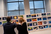 Jack Barrett and Anita Gaul of the State Emblems Redesign Commission hang up some of the 216 flag designs that made the first cut from the original 21