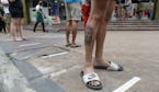 Residents step on measured tape placed outside a supermarket to practice social distancing as a precautionary measure against the spread of the corona