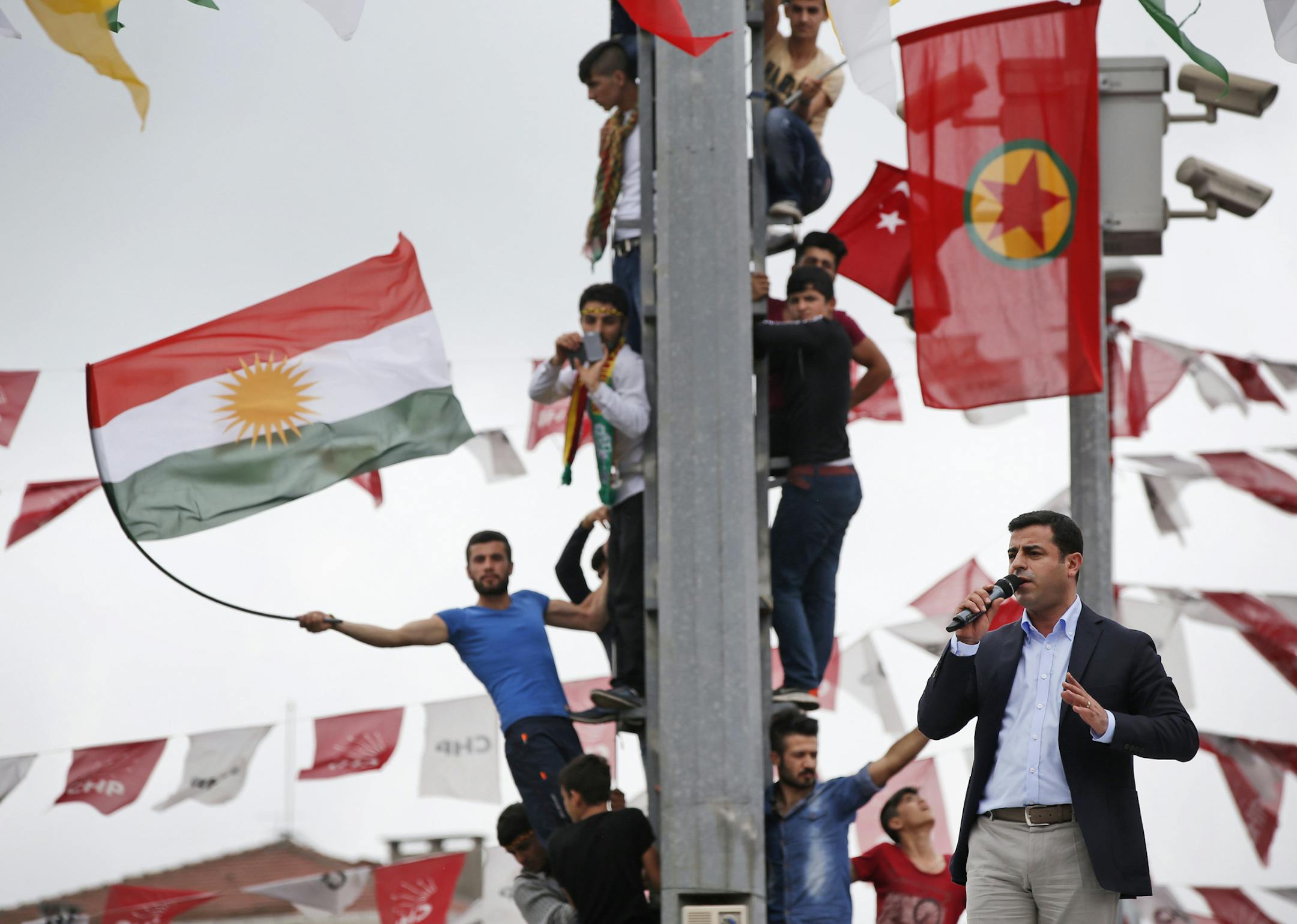 Selahattin Demirtas, right, co-chair of the pro-Kurdish Peoples' Democratic Party (HDP), delivers a speech from the top of his election campaign bus at a rally in Istanbul, Turkey, Saturday, June 6, 2015 ahead of the general election on Sunday June 7. Although it is a relatively small party, all eyes will be on HDP. If it reaches the minimum 10 percent threshold required for entering parliament as a party, it could effectively thwart Turkey's President Recep Tayyip Erdogan’s ambition to l