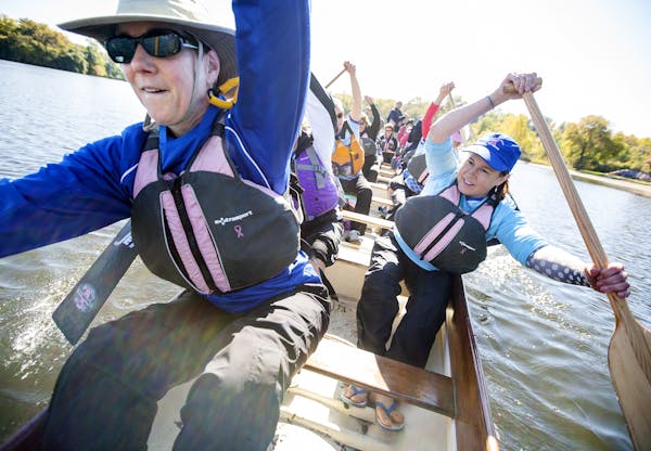 Dr. Judith Trudel, left, and Ginny Heinrich, both of Woodbury, paddle with fellow Courage teammates as the Dragon Divas train on Lake Gervais in Littl