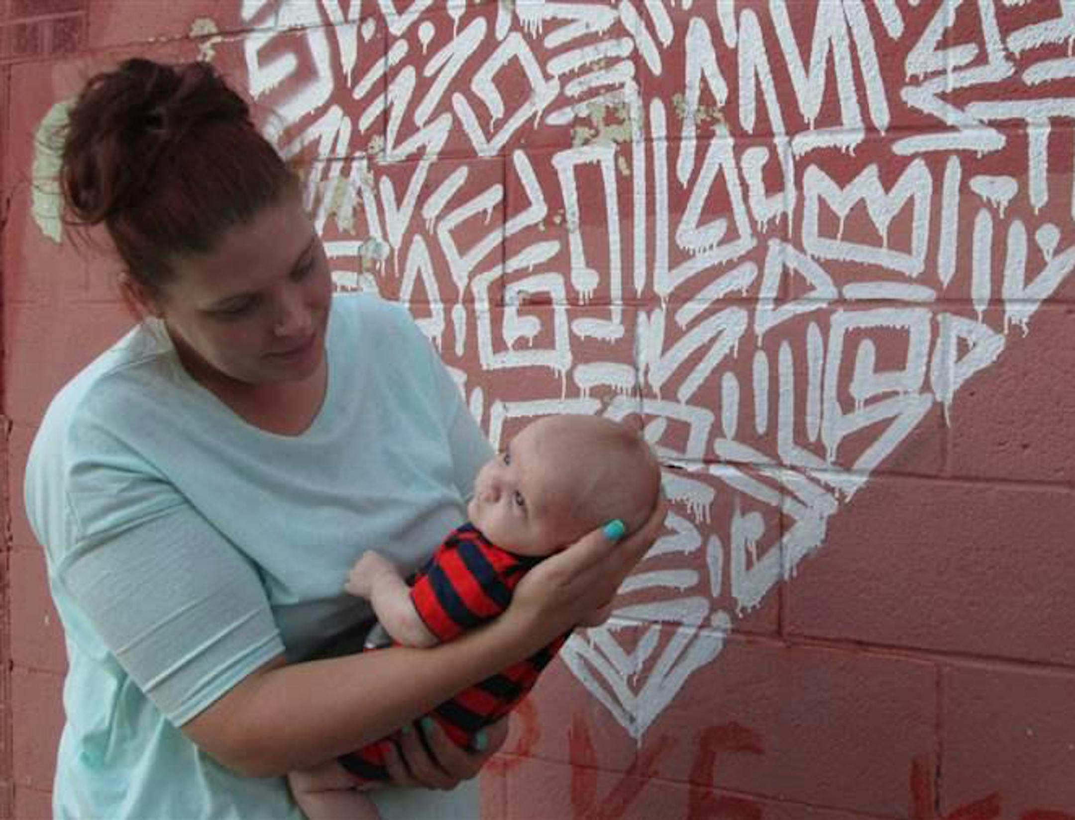 Stephanie Petitt holds baby Legend outside of ReMerge's offices in Oklahoma City. The program aims to keep mothers out of prison and with their children. (Pew Charitable Trusts)