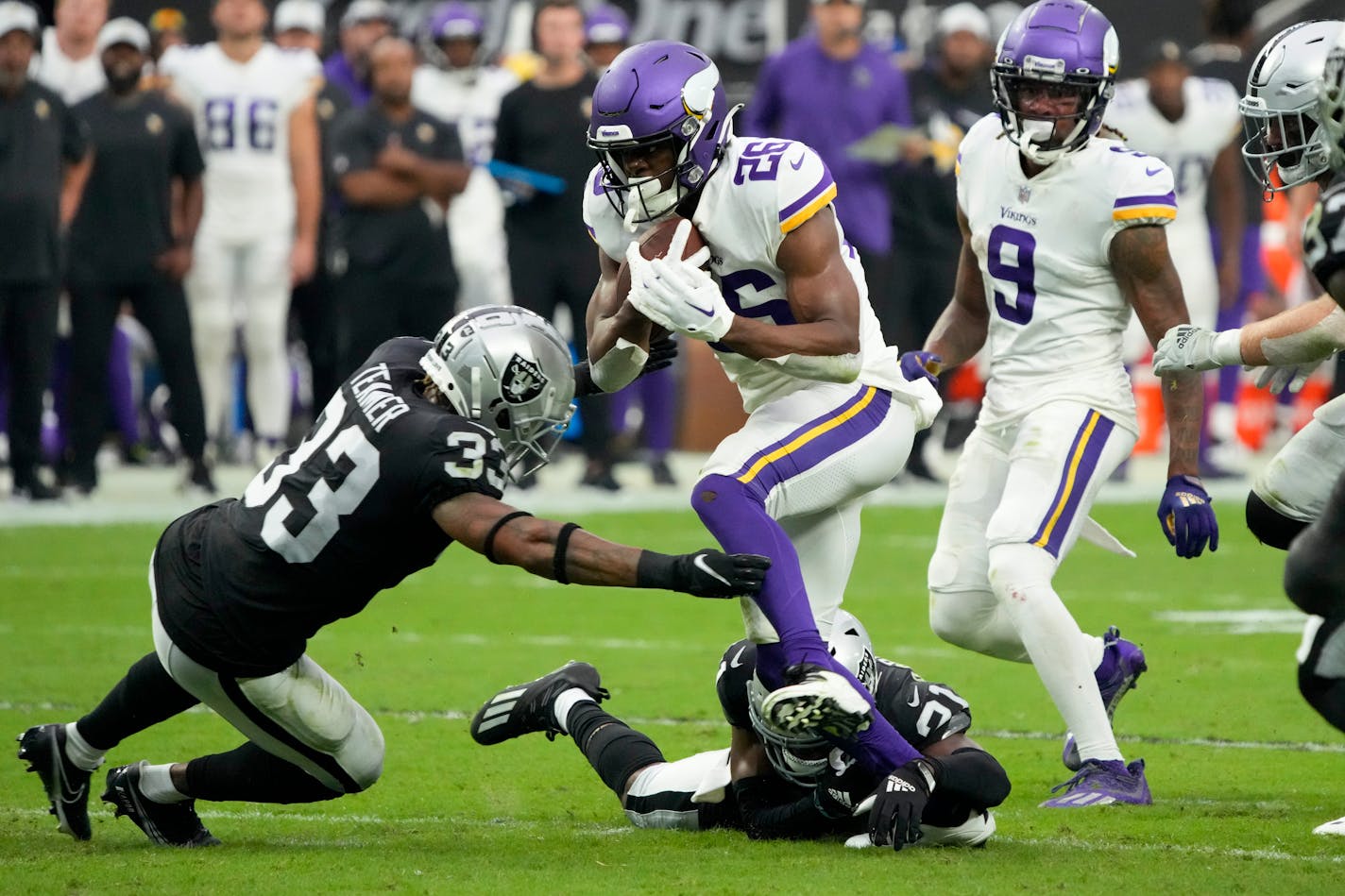 Minnesota Vikings running back Kene Nwangwu runs past Las Vegas Raiders cornerback Cre'Von LeBlanc and safety Roderic Teamer during the first half of an NFL preseason football game, Sunday, Aug. 14, 2022, in Las Vegas. (AP Photo/Rick Scuteri)