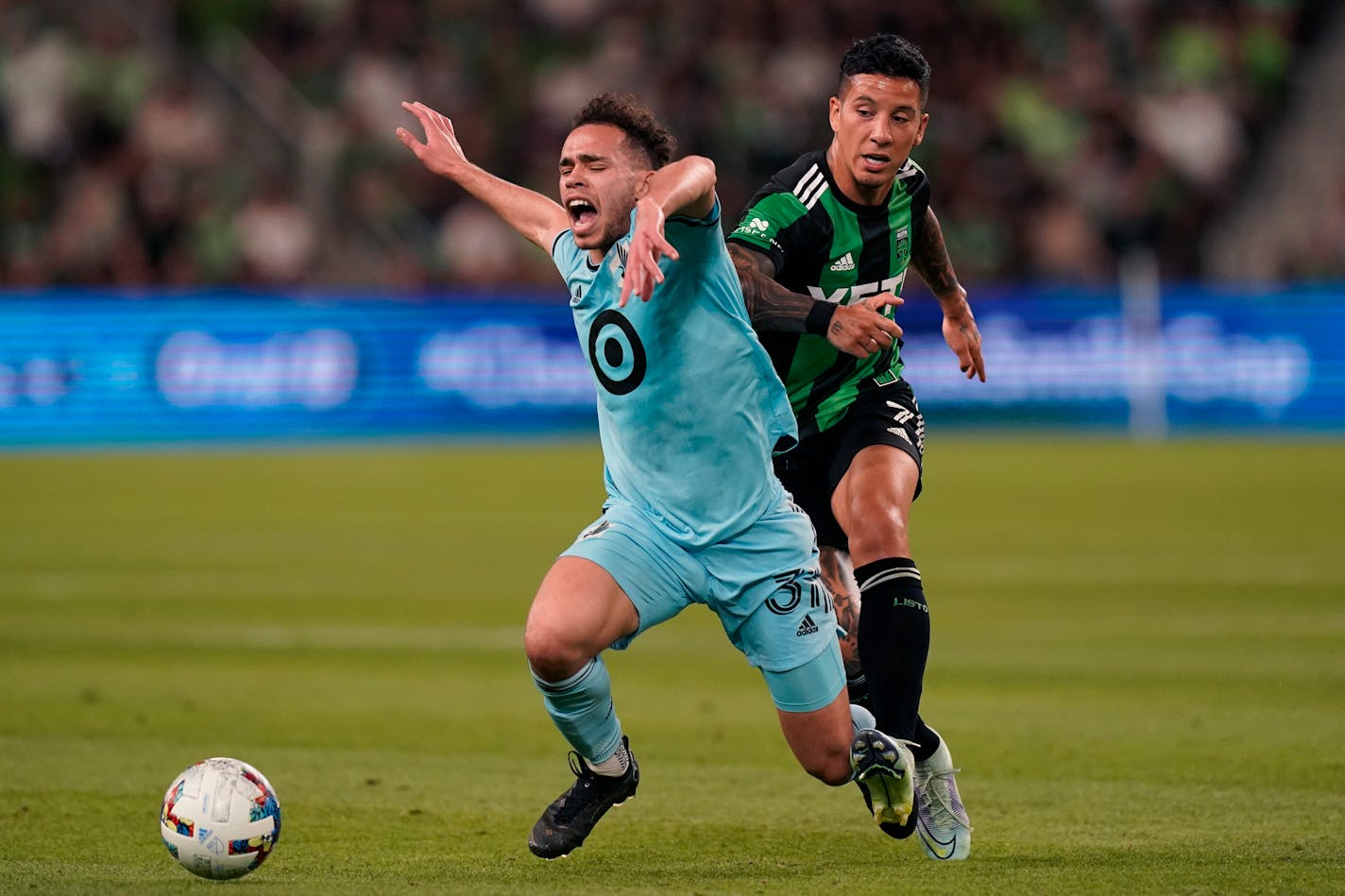 Minnesota United FC midfielder Hassani Dotson (31) is tripped up by Austin FC forward Sebastian Driussi (7) during the second half of an MLS soccer match, Sunday, April 10, 2022, in San Antonio. (AP Photo/Eric Gay)